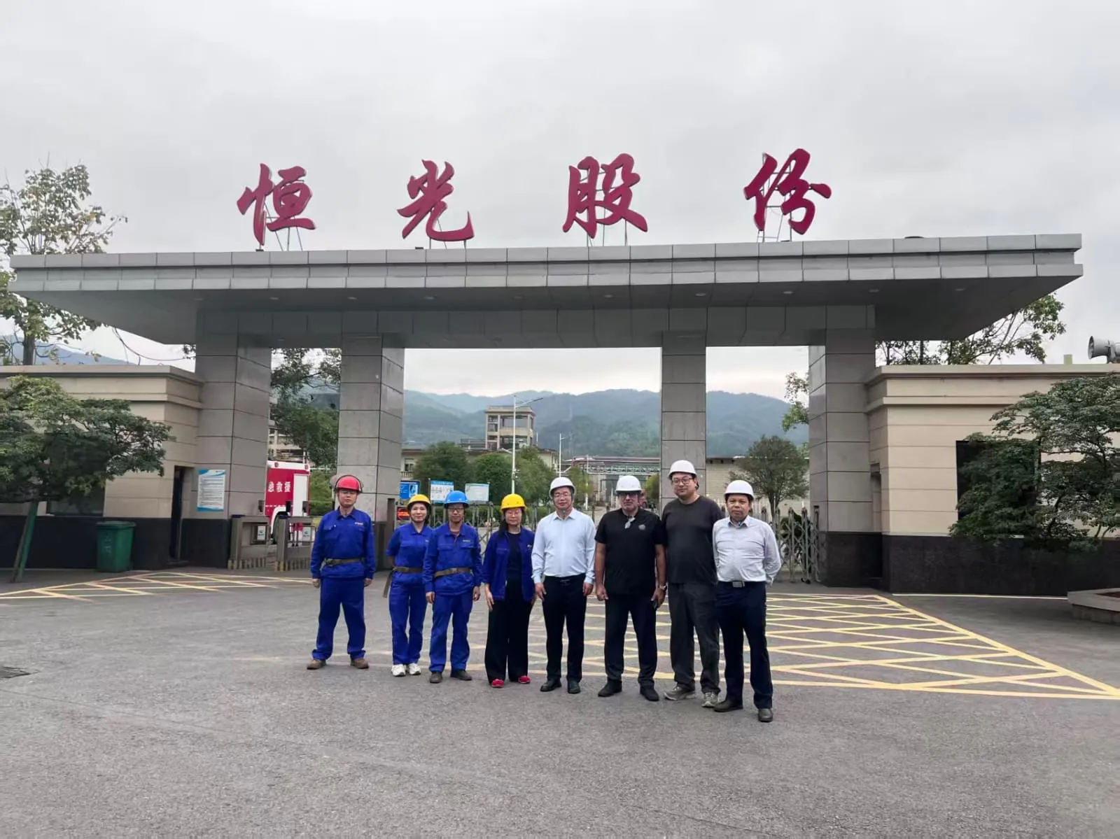 Tim GFTx dan Hengguang mengenakan helm keselamatan di depan gerbang utama Hengguang di Hunan, China